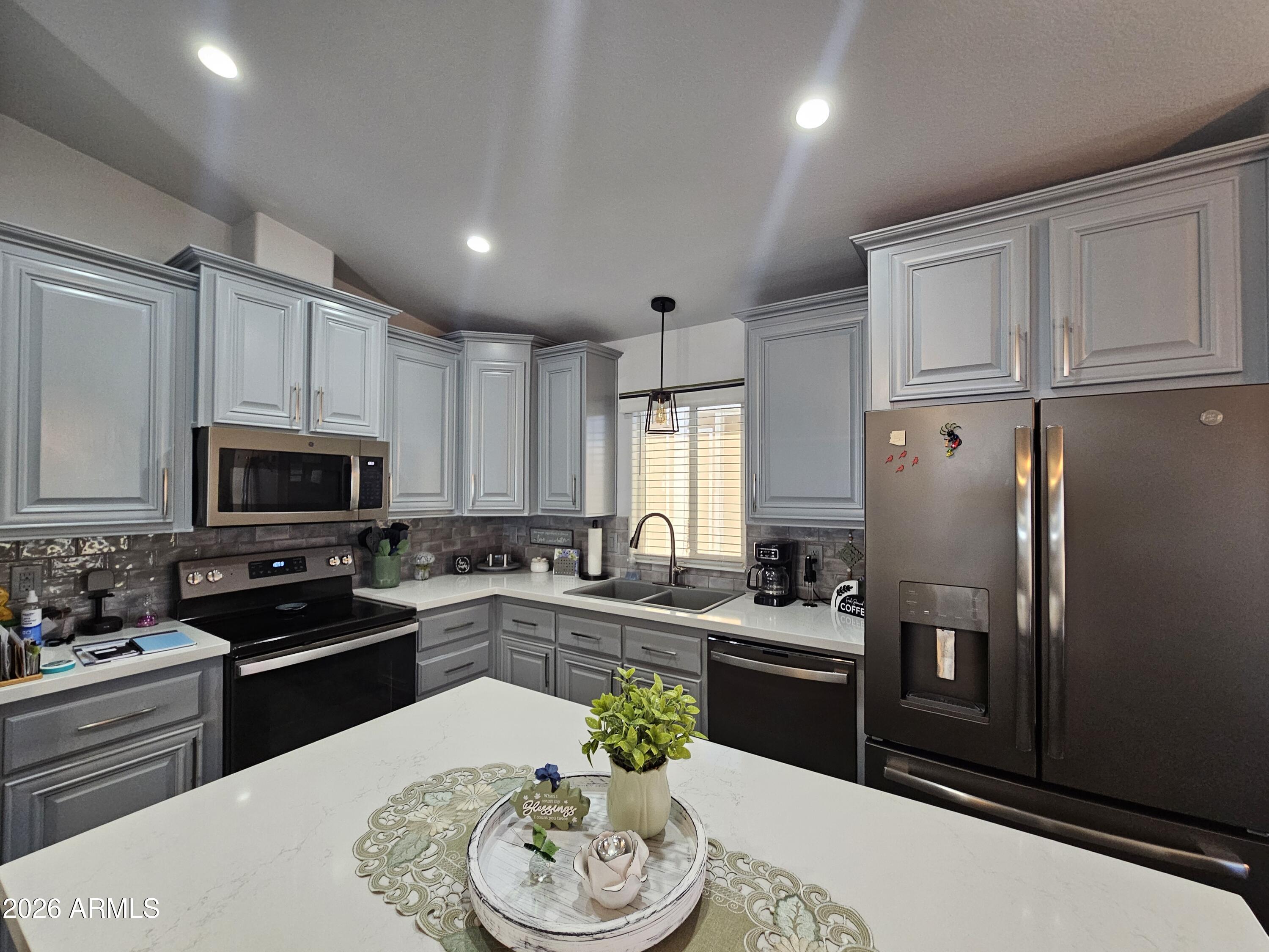 650 North Hawes Road, Unit 3406 Mesa, AZ 85207 - Photo 10 of 45 a kitchen with granite countertop stainless steel appliances a refrigerator a stove a sink a dining table and chairs