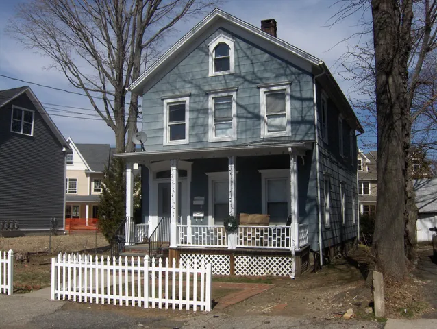 a view of a brick house with large windows and a large tree