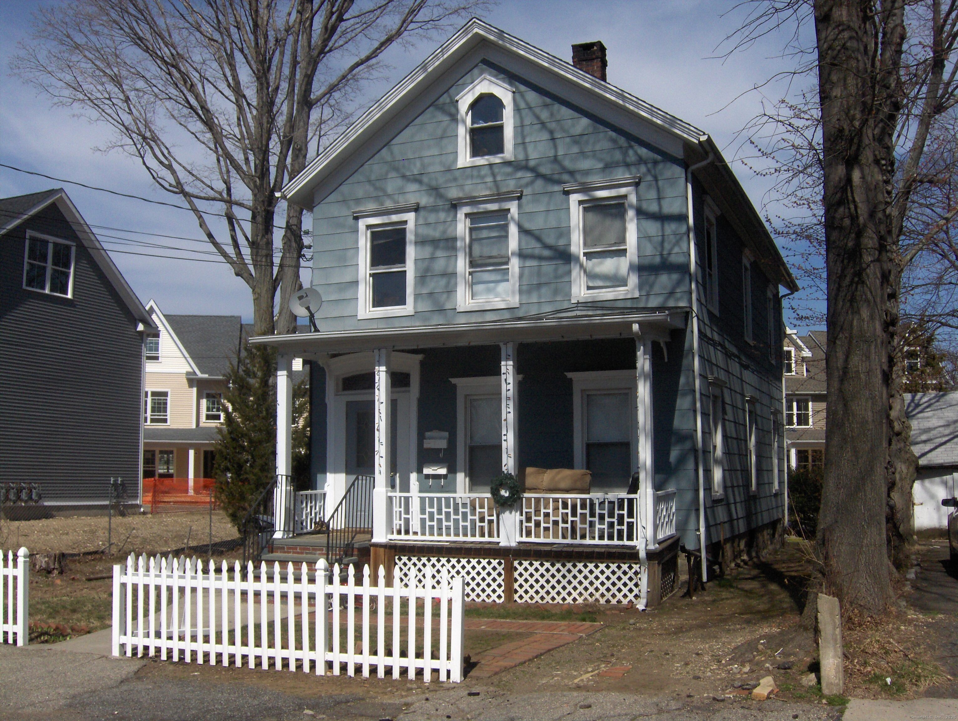 a view of a brick house with large windows and a large tree