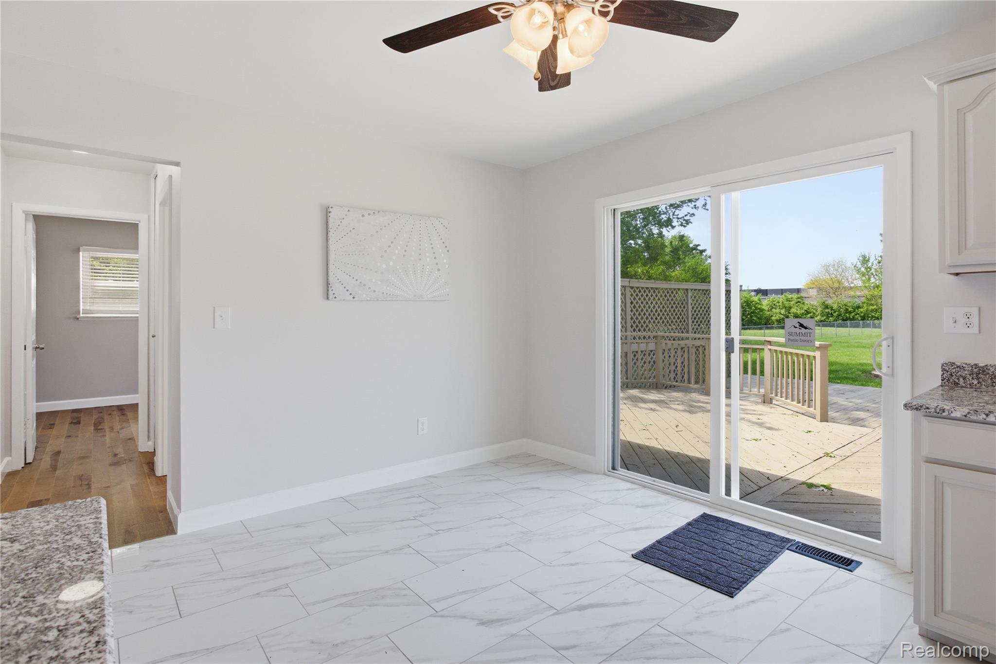 37257 Dundee Street Sterling Heights, MI 48310 - Photo 16 of 47 Bright interior space featuring large format tile flooring, a ceiling fan with integrated lighting, and a sliding glass door