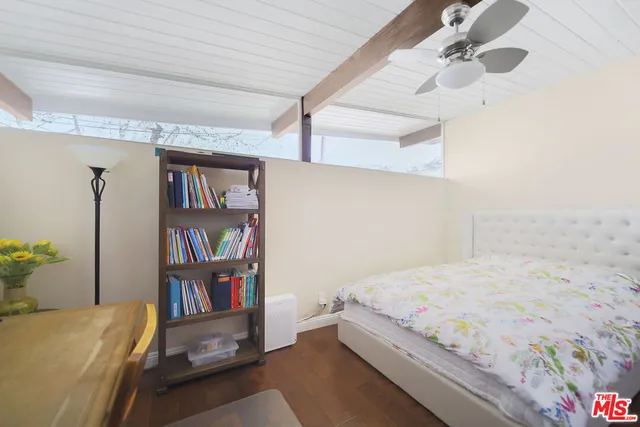 a bedroom with a bed and a book shelf