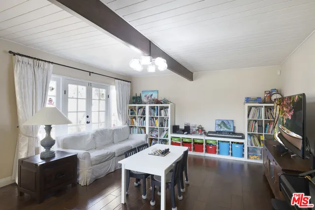 a living room with furniture a flat screen tv and a book shelf