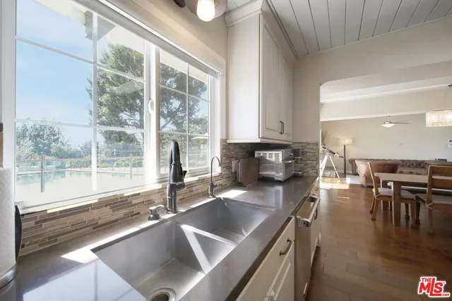 a kitchen with stainless steel appliances granite countertop a sink a stove and a wooden cabinets