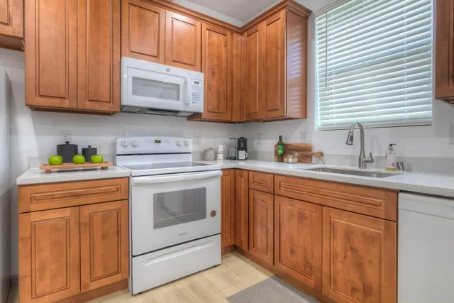 a kitchen with stainless steel appliances granite countertop a sink a stove and cabinets