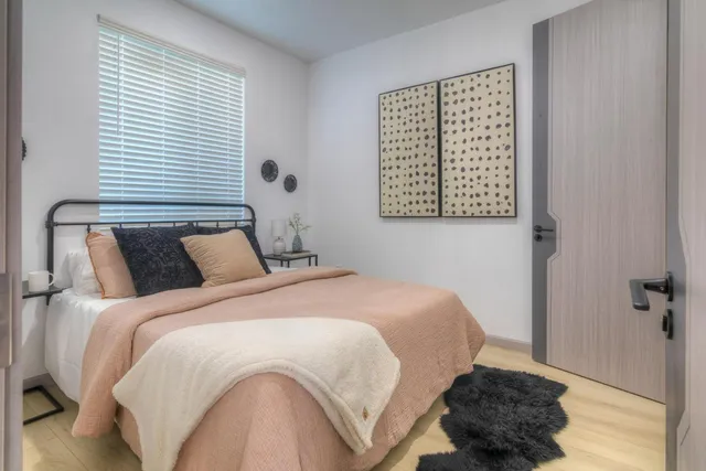 a bedroom with a bed and wooden floor