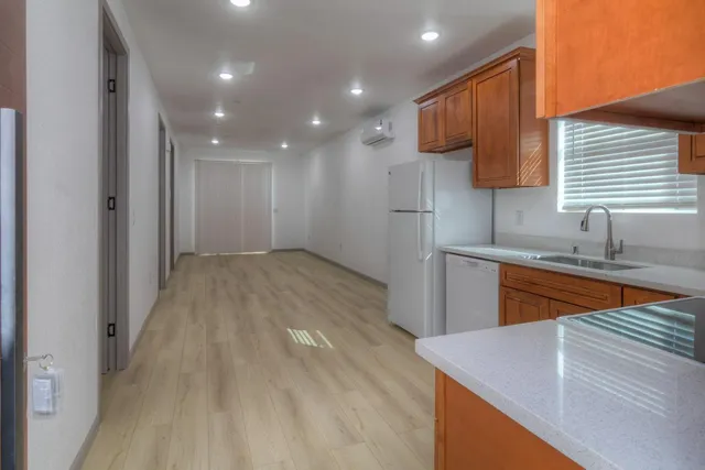 a kitchen with a sink cabinets and wooden floor