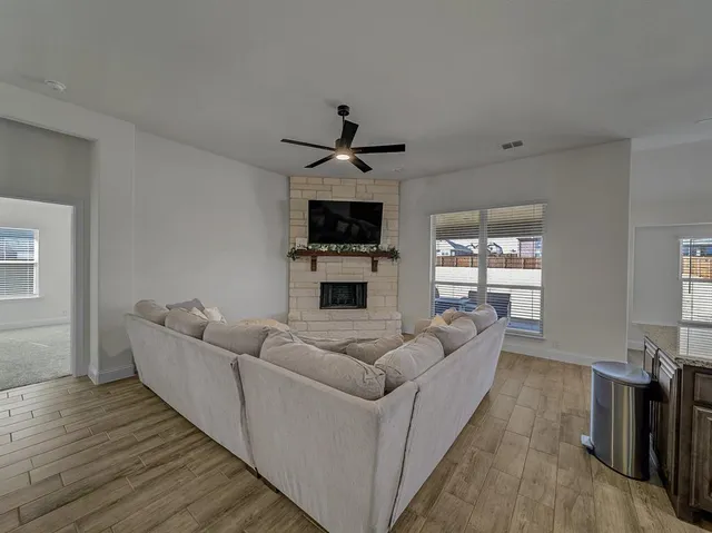 a living room with furniture a fireplace and a flat screen tv