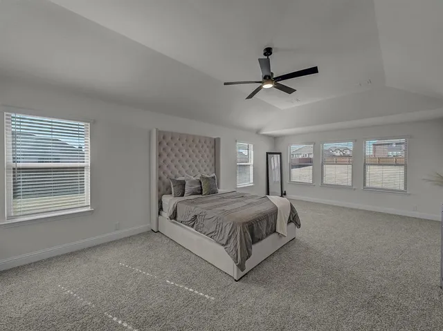 a spacious bedroom with a bed couch and window