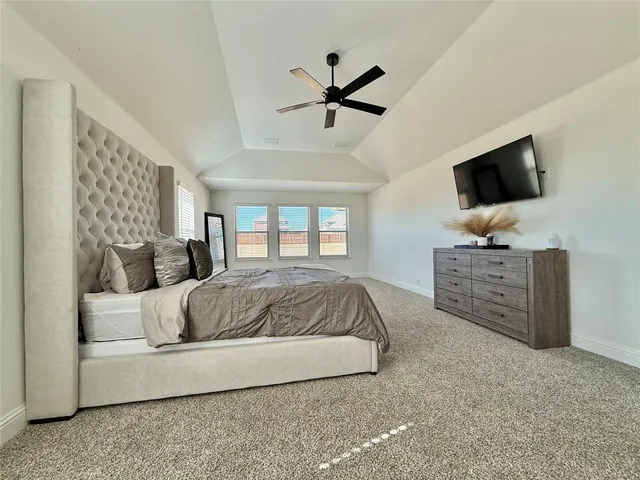 a spacious bedroom with a bed and a flat screen television