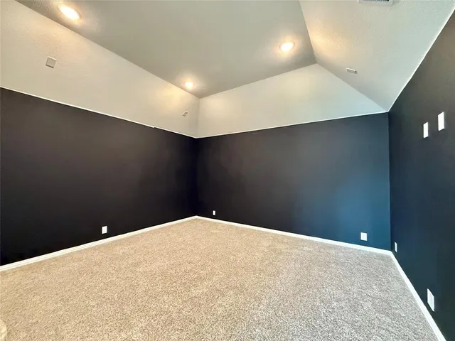 a bed sitting in a bedroom next to a window and a chandelier