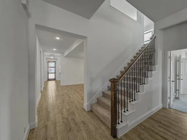 a view of a hallway with wooden floor and entryway