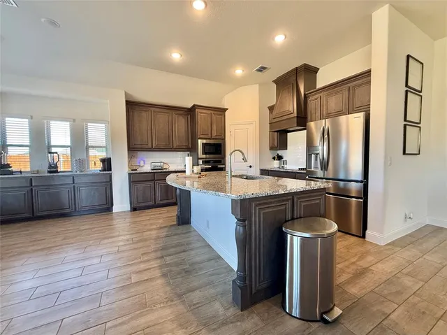 a large kitchen with stainless steel appliances wooden cabinets and granite counter tops