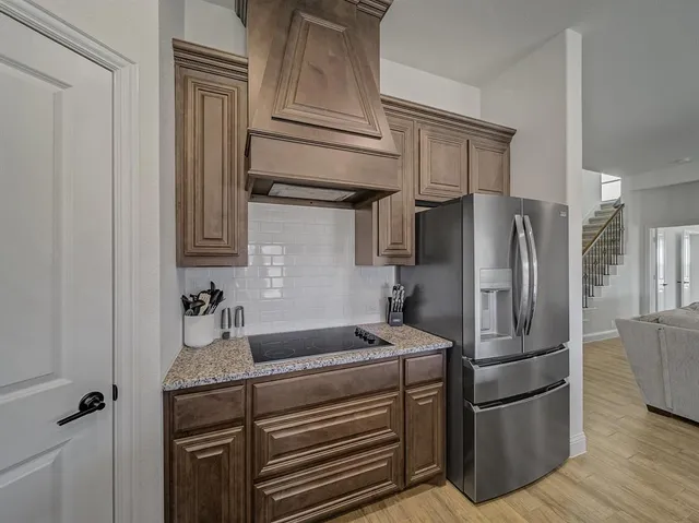 a kitchen with stainless steel appliances granite countertop a refrigerator and a sink