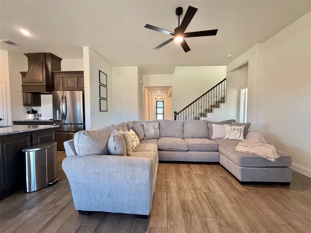a living room with furniture and a wooden floor