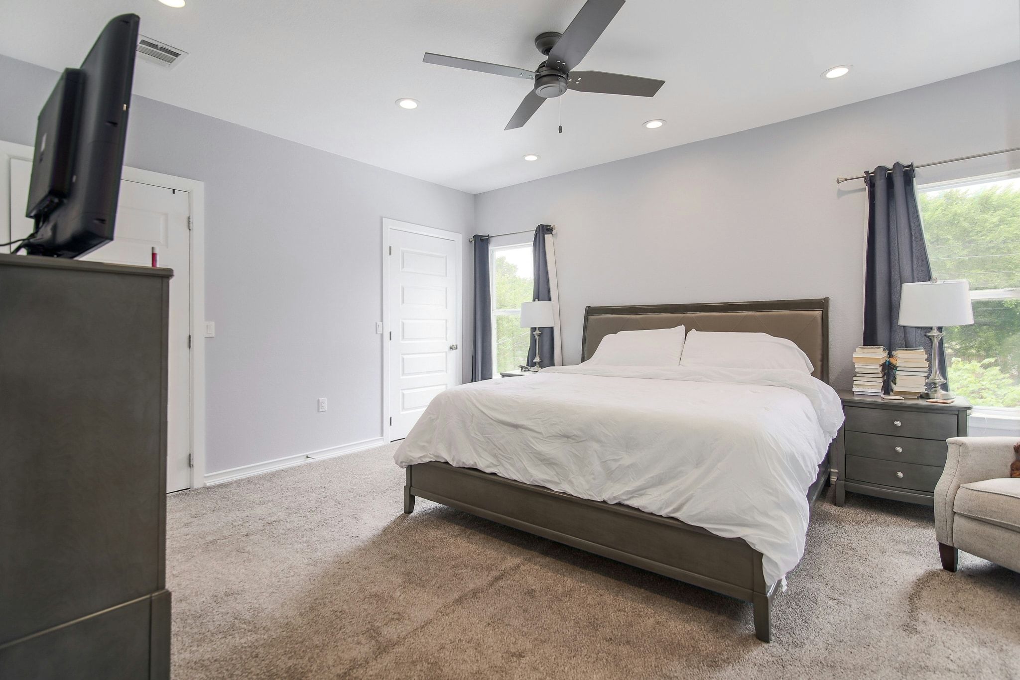 2109 Maxwell Lane, Unit A Austin, TX 78741 - Photo 18 of 27 a spacious bedroom with a bed and a flat tv screen on a dresser
