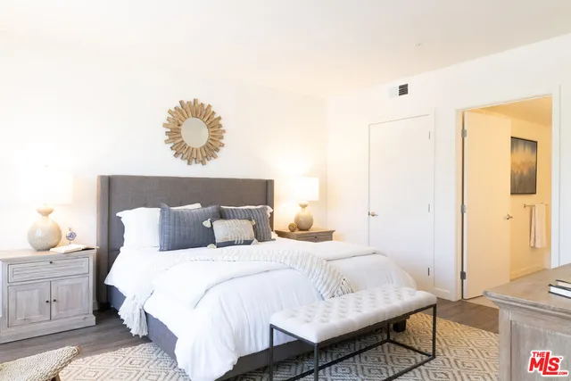 a bedroom with a bed and wooden floor