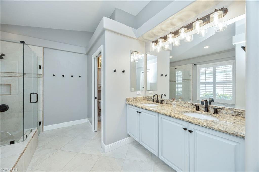 20350 Talon Trace Estero, FL 33928 - Photo 15 of 24 Bathroom with double vanity, a stall shower, and light tile patterned floors