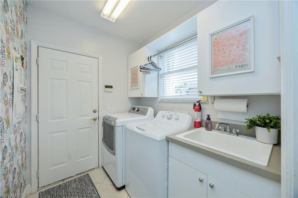 20350 Talon Trace Estero, FL 33928 - Photo 19 of 24 Laundry room with cabinet space, washer and dryer, and light tile patterned floors