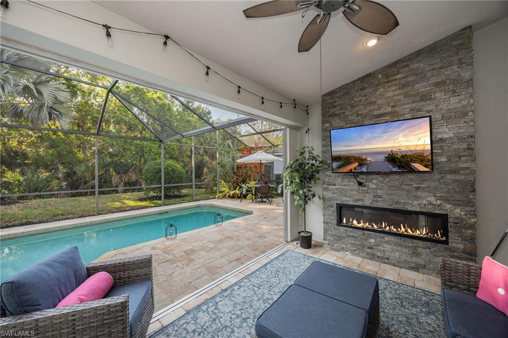20350 Talon Trace Estero, FL 33928 - Photo 3 of 24 Swimming pool featuring a patio, a sunroom, glass enclosure, and an outdoor living space with a fireplace