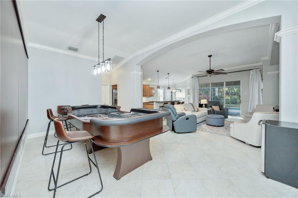 20350 Talon Trace Estero, FL 33928 - Photo 8 of 24 Dining area with a ceiling fan, ornamental molding, lofted ceiling, arched walkways, and light tile patterned floors