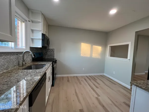 a kitchen with granite countertop wooden cabinets a sink and dishwasher