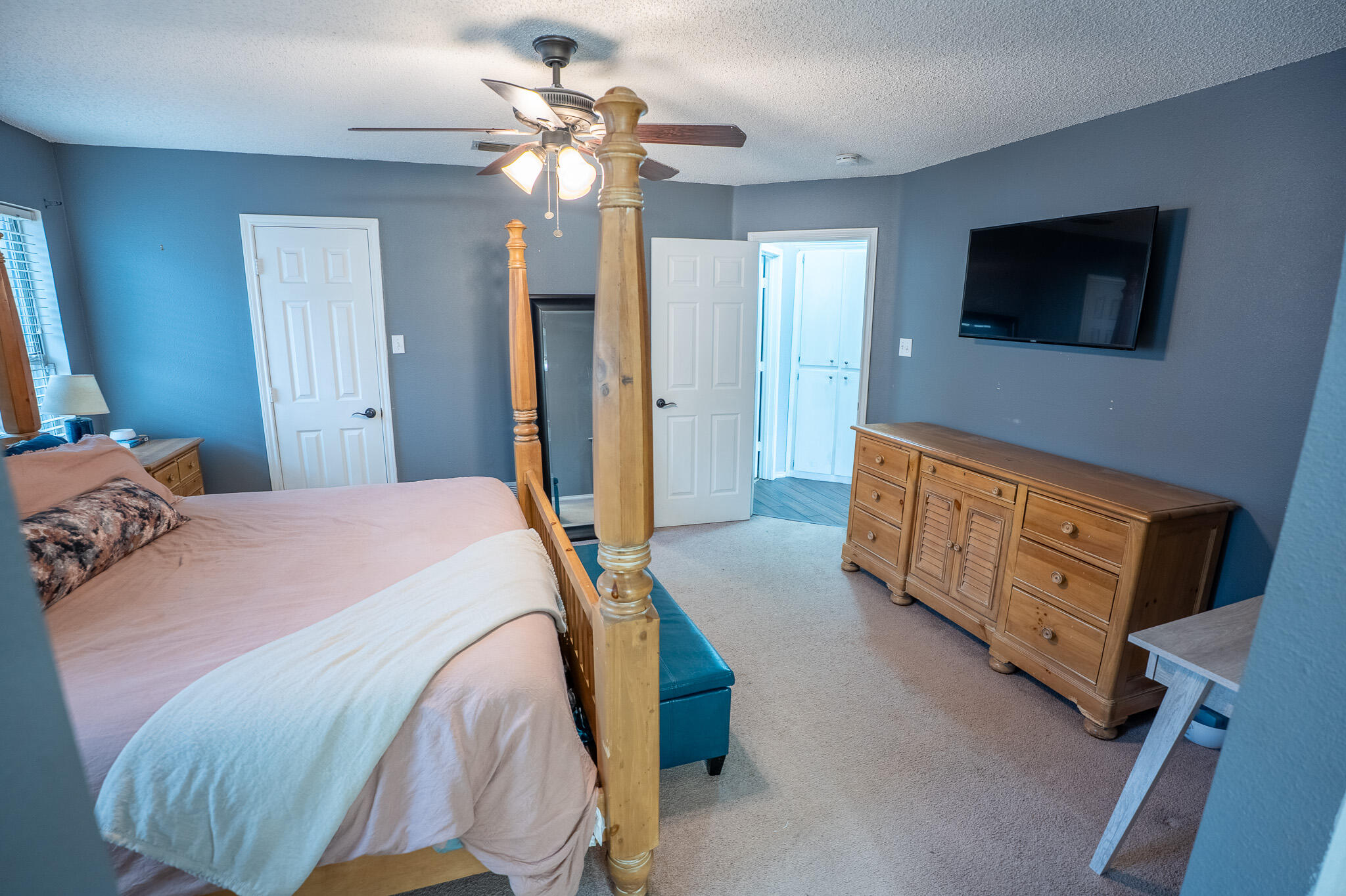1609 78th Street Lubbock, TX 79423 - Photo 16 of 36 a spacious bedroom with a bed and a flat screen tv