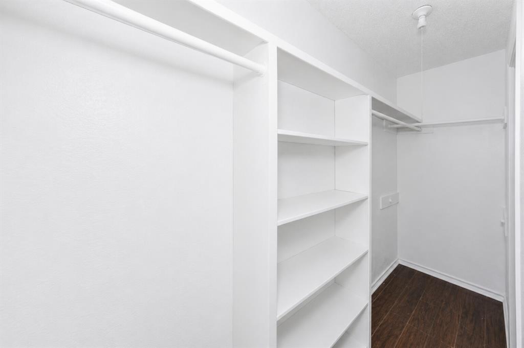 1001 Rosebud Drive Azle, TX 76020 - Photo 22 of 36 Walk-in closet featuring built-in shelving, white walls, dark wood-finish flooring, and white hanging rods