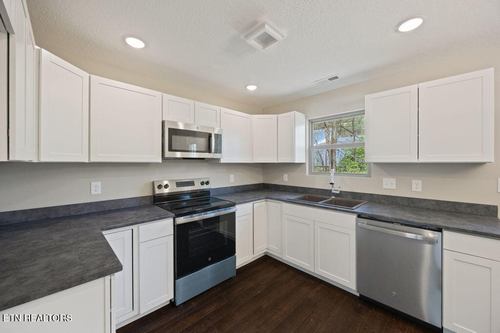 503 Hillcrest Street Clinton, TN 37716 - Photo 5 of 19 a kitchen with granite countertop white cabinets and stainless steel appliances