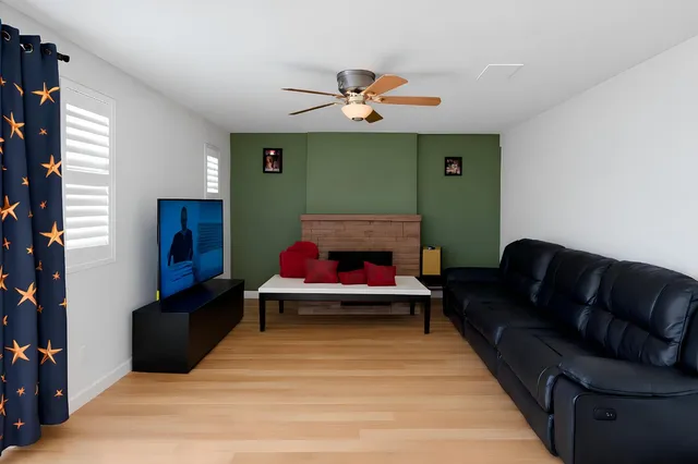 a living room with furniture and a ceiling fan