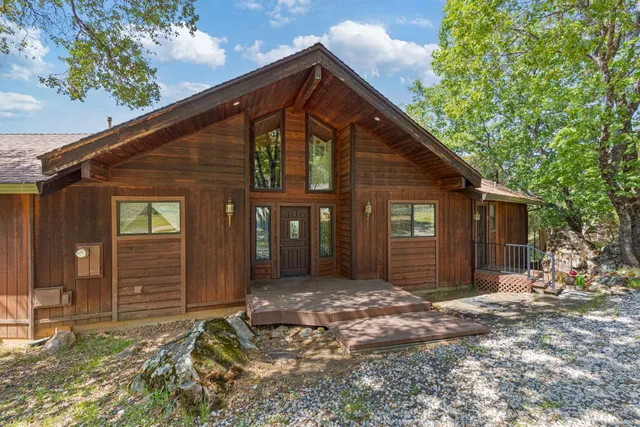 a kitchen with stainless steel appliances kitchen island granite countertop a table chairs and a refrigerator