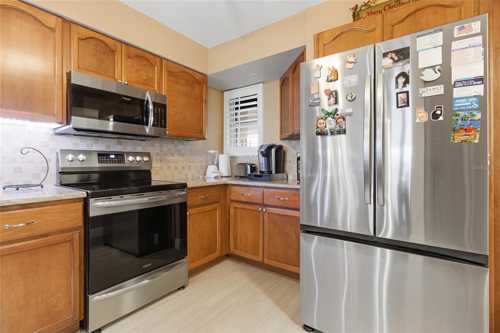 5567 Sea Forest Drive, Unit 323 New Port Richey, FL 34652 - Photo 11 of 37 a kitchen with stainless steel appliances a refrigerator stove microwave and sink