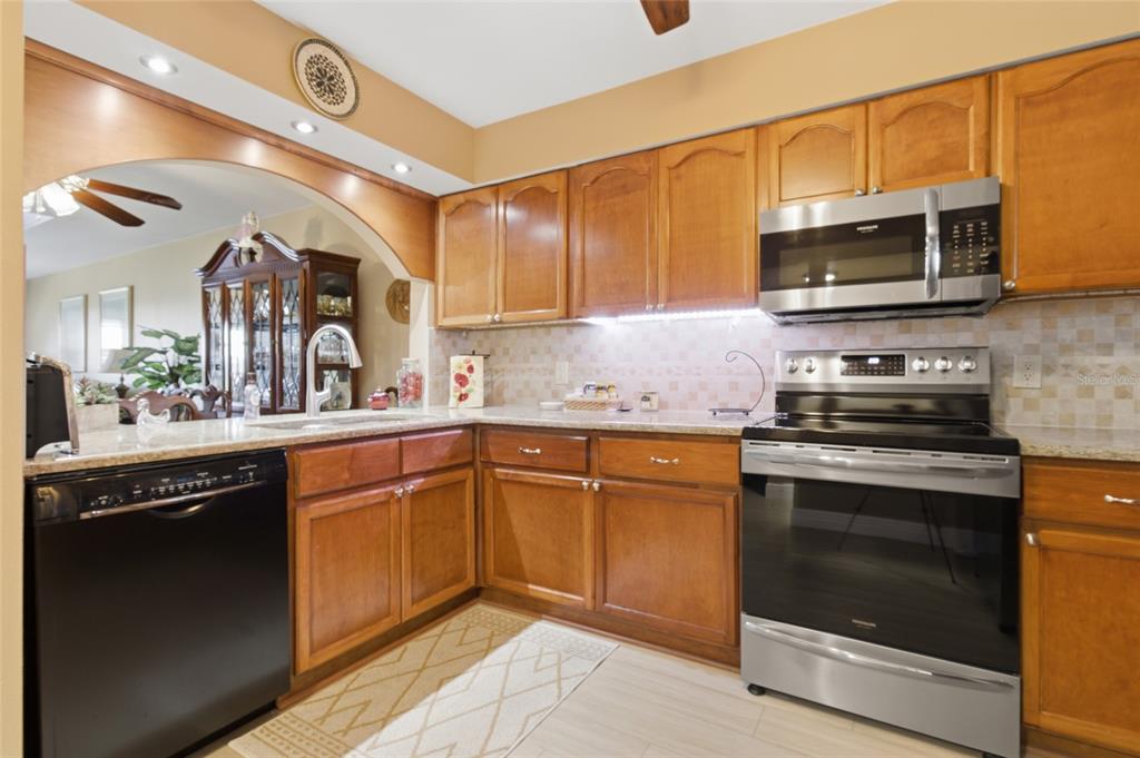5567 Sea Forest Drive, Unit 323 New Port Richey, FL 34652 - Photo 12 of 37 a kitchen with stainless steel appliances granite countertop a stove microwave and sink