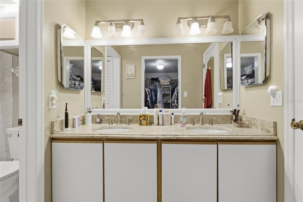 5567 Sea Forest Drive, Unit 323 New Port Richey, FL 34652 - Photo 16 of 37 a bathroom with a granite countertop sink double vanity and a mirror