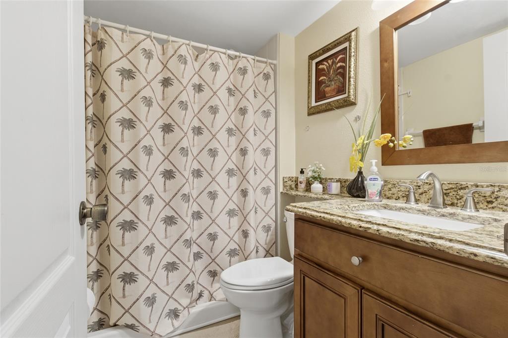 5567 Sea Forest Drive, Unit 323 New Port Richey, FL 34652 - Photo 25 of 37 a bathroom with a granite countertop sink and a toilet