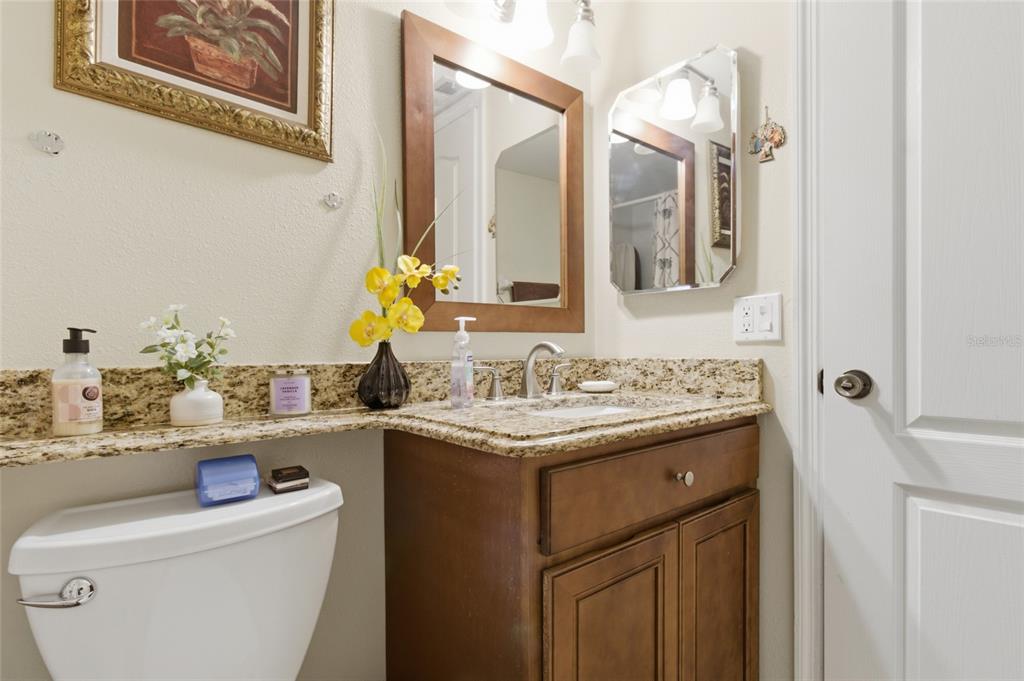 5567 Sea Forest Drive, Unit 323 New Port Richey, FL 34652 - Photo 26 of 37 a bathroom with a granite countertop sink and a mirror