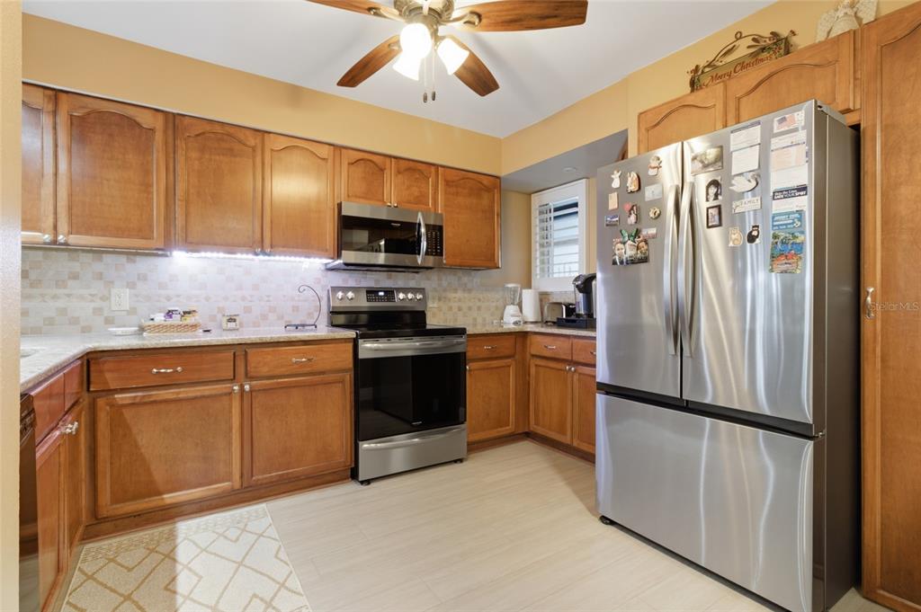 5567 Sea Forest Drive, Unit 323 New Port Richey, FL 34652 - Photo 10 of 37 a kitchen with stainless steel appliances granite countertop a refrigerator a stove and a sink