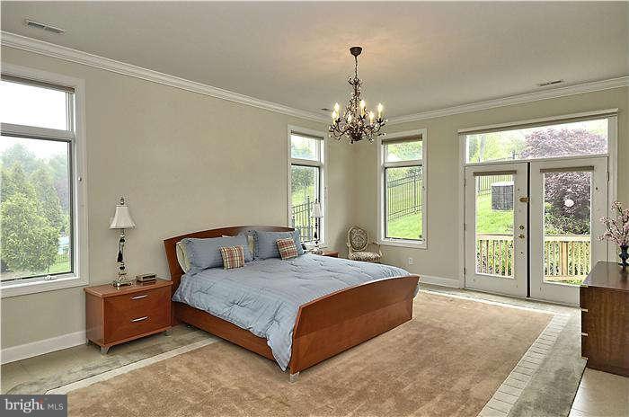 11505 Big Piney Way Potomac, MD 20854 - Photo 16 of 29 a bedroom with a large bed and a chandelier