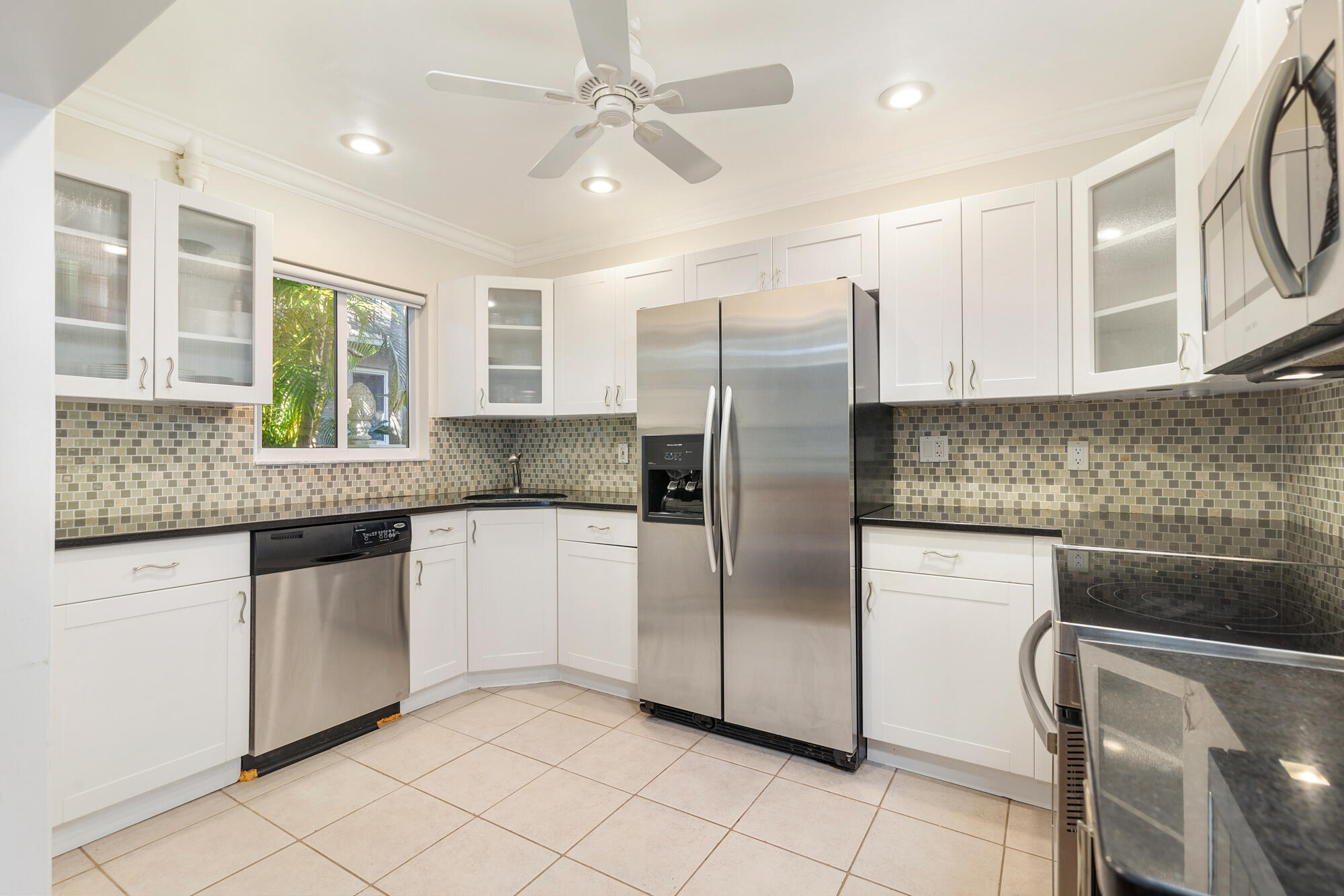 248 Cortez Road West Palm Beach, FL 33405 - Photo 7 of 27 a kitchen with granite countertop a refrigerator a sink and white cabinets