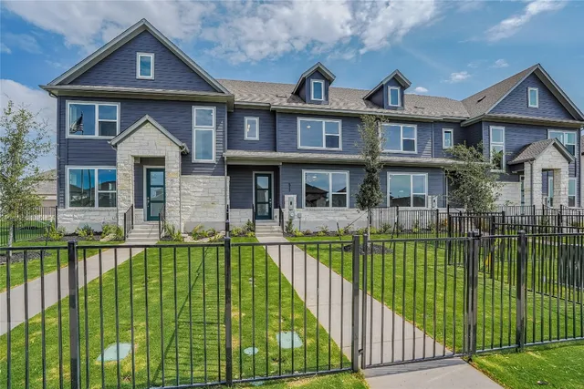 a front view of a house with a garden and lake view
