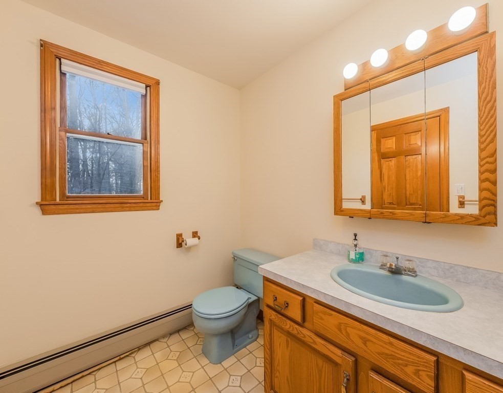 4 Uplands Road Littleton, MA 01460 - Photo 36 of 39 a bathroom with a granite countertop sink mirror vanity and toilet