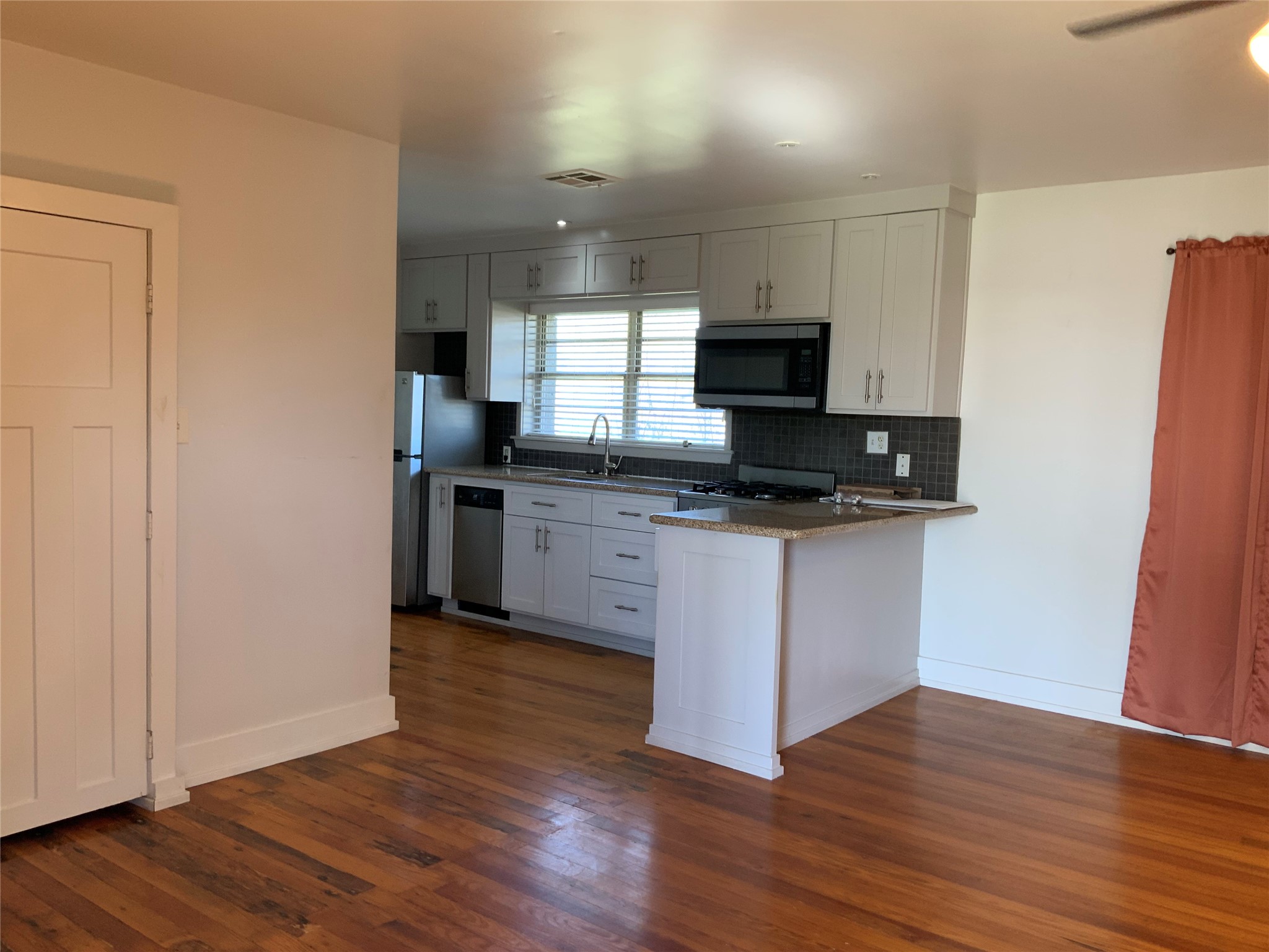 100 West Madison Street, Unit A Trinity, TX 75862 - Photo 8 of 24 a kitchen with granite countertop a refrigerator and a stove top oven