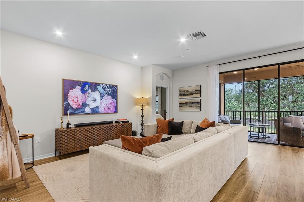 3793 Costa Maya Way, Unit 202 Estero, FL 33928 - Photo 12 of 28 a living room with furniture large window and wooden floor