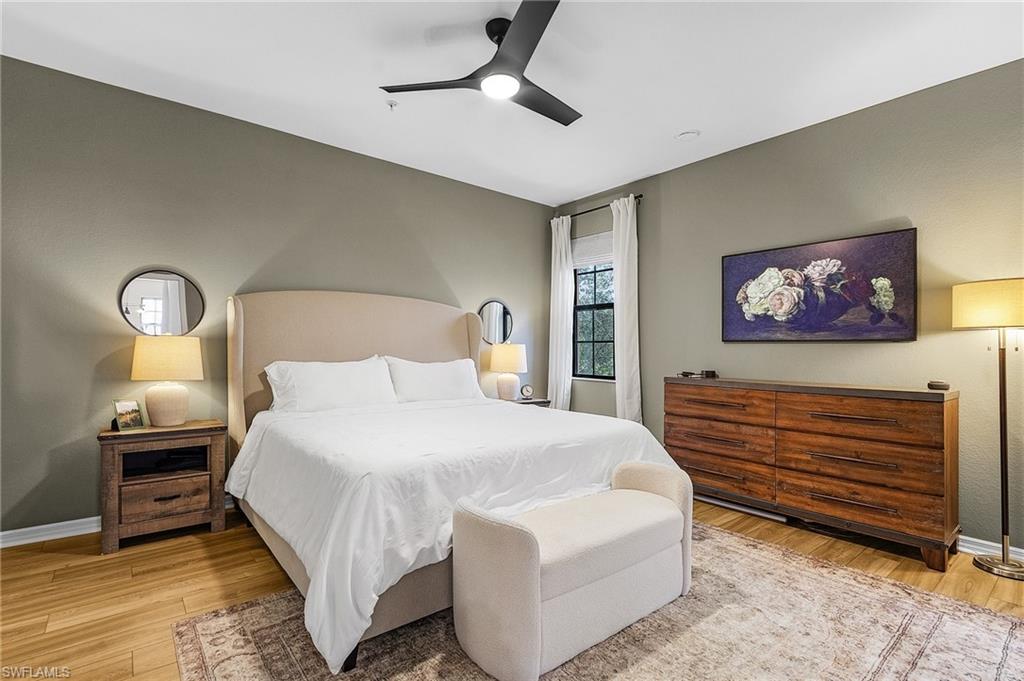 3793 Costa Maya Way, Unit 202 Estero, FL 33928 - Photo 15 of 28 a bedroom with a bed and a chandelier