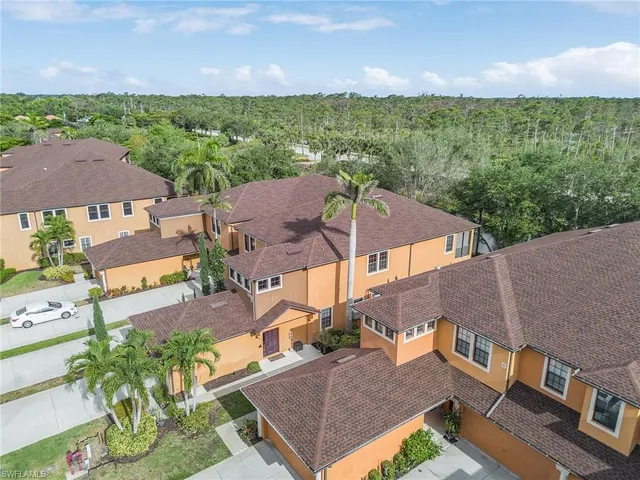 an aerial view of residential houses with outdoor space and trees