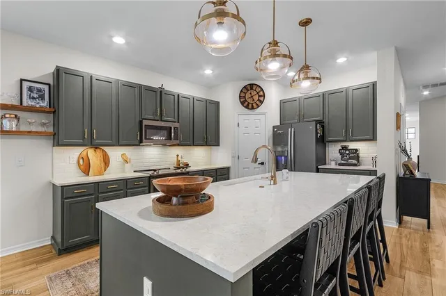a kitchen with a stove a kitchen island a sink and a refrigerator