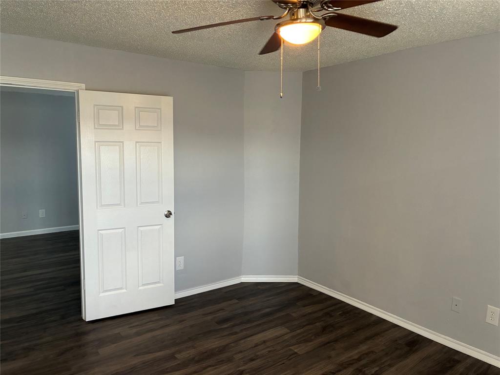 6108 Abrams Road, Unit 306 Dallas, TX 75231 - Photo 15 of 17 Spare room with a textured ceiling, dark wood-type flooring, and a ceiling fan