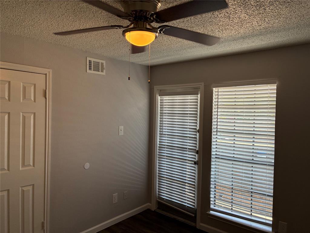 6108 Abrams Road, Unit 306 Dallas, TX 75231 - Photo 8 of 17 Spare room featuring a textured ceiling, a ceiling fan, and dark wood-style flooring