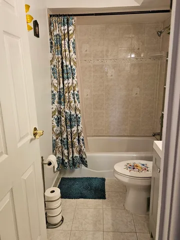 a bathroom with a toilet and a shower curtain