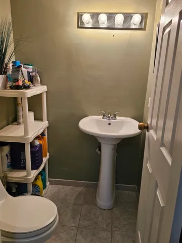 a bathroom with a sink a toilet and a mirror