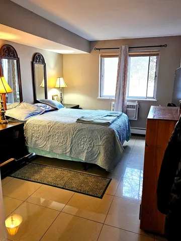 a bedroom with a bed and dresser with mirror